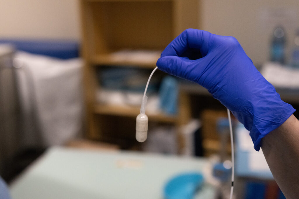 Professionnelle de santé expliquant la procédure du ballon gastrique Allurion à un patient avant l’ingestion, dans une salle clinique.