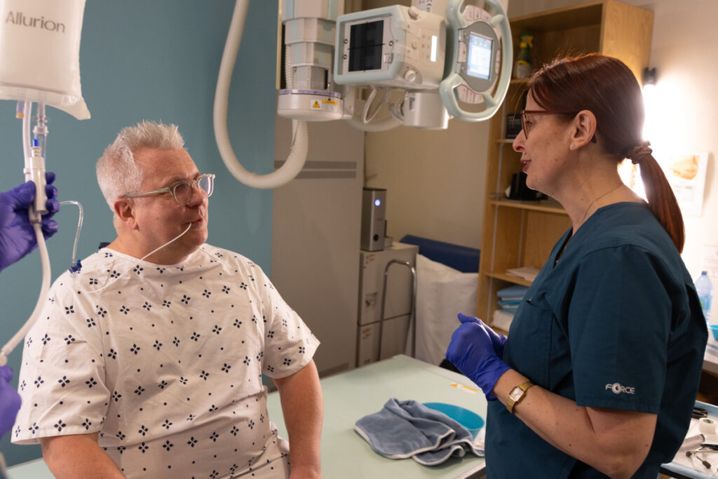 Professionnelle de santé expliquant la procédure du ballon gastrique Allurion à un patient avant l’ingestion, dans une salle clinique.